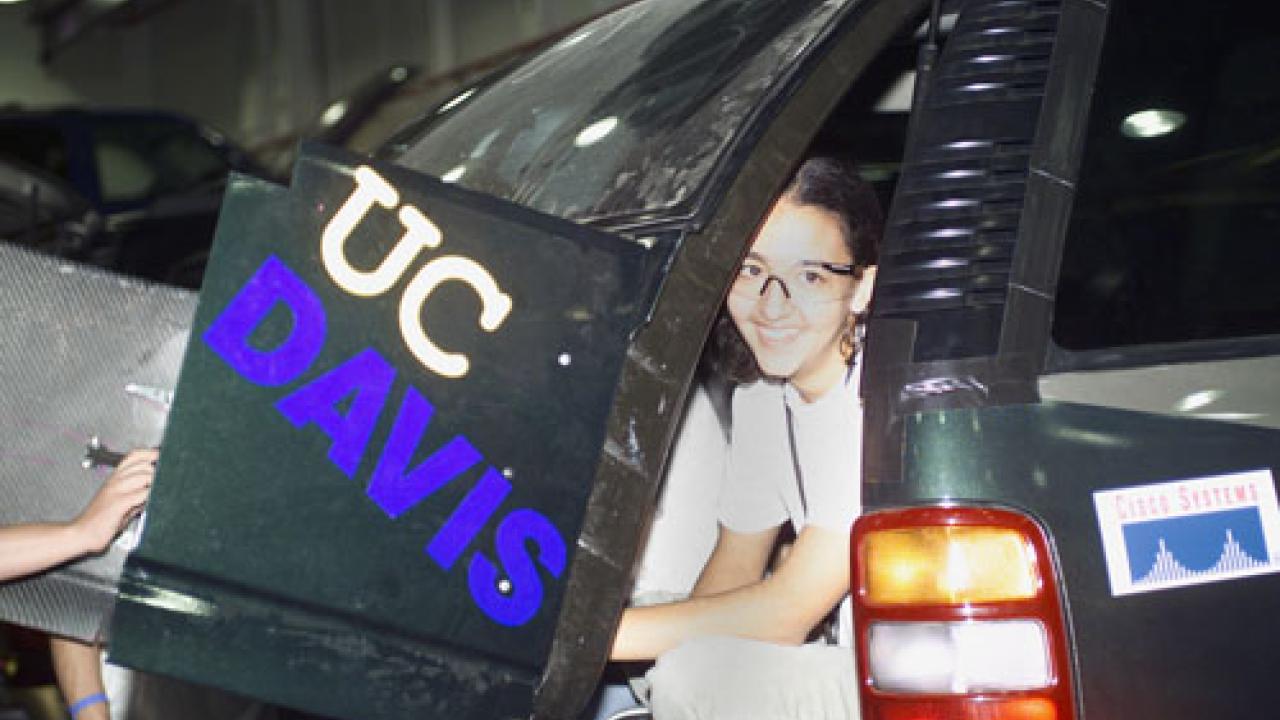 EcoCAR Faculty Advisor is opening a car door with UC Davis written on it