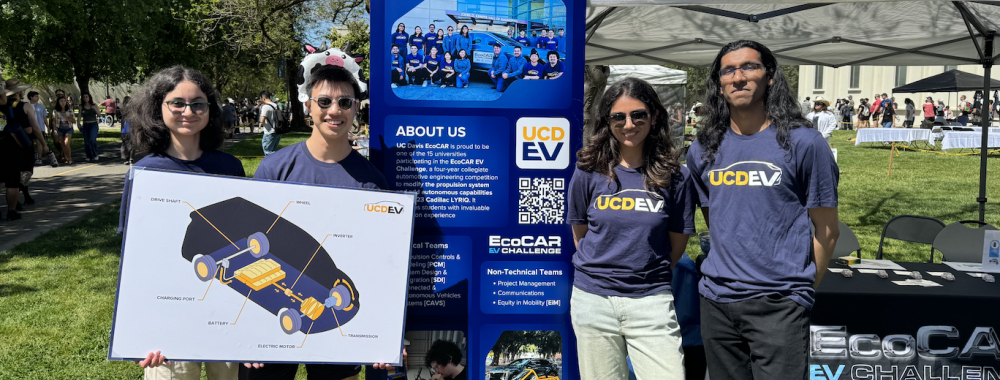 Comms Team Standing in front of EcoCAR Table at picnic day